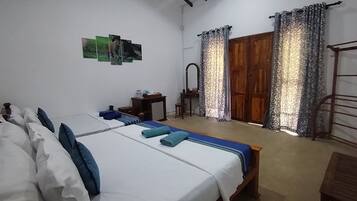 A bedroom with a bed, a small table, a mirror, and a wardrobe.