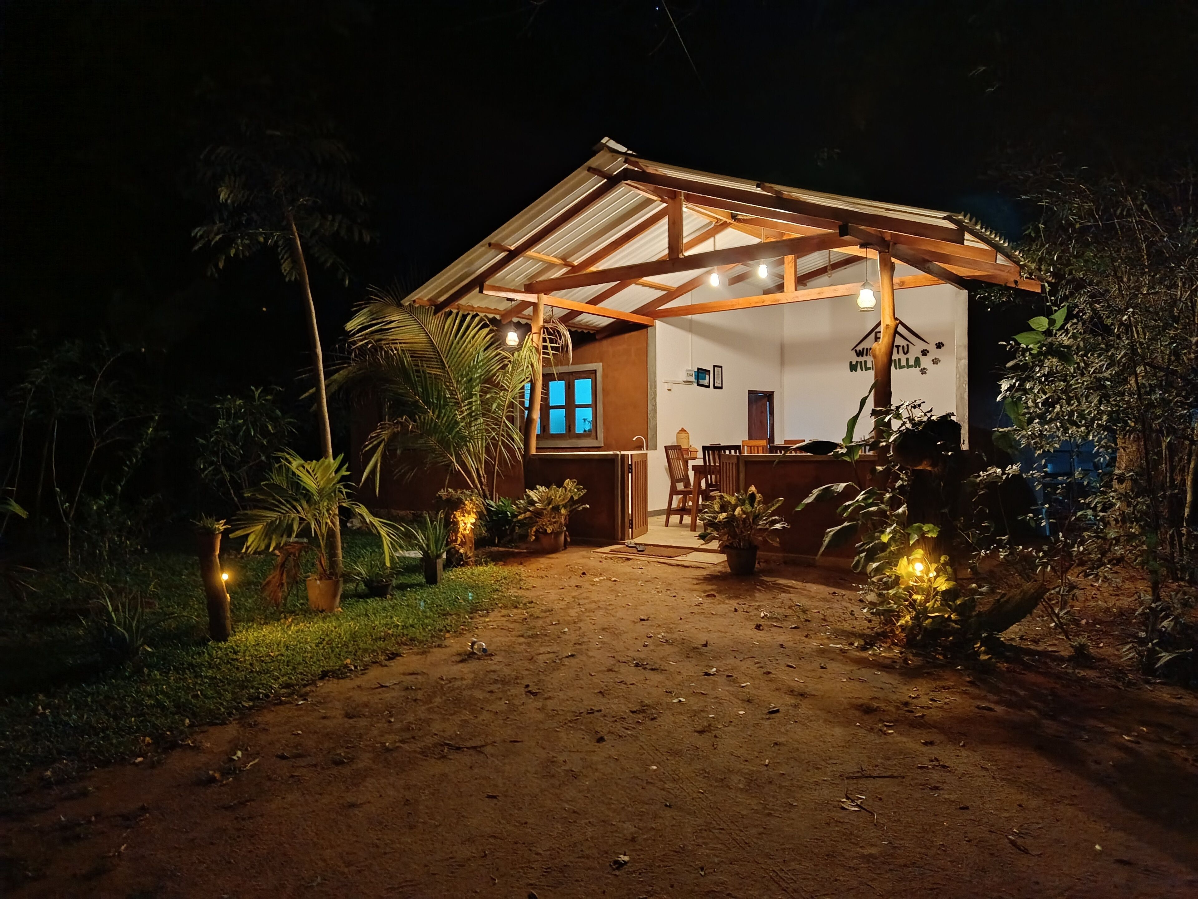 Una casa de madera rústica con un porche cubierto, un comedor y un ventanal visible.