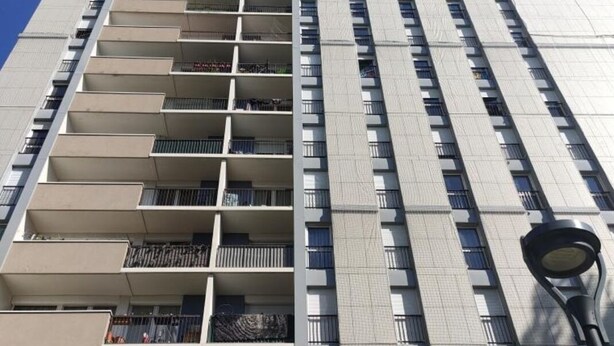 Un immeuble moderne et imposant, doté de nombreux balcons et d’un lampadaire.