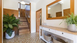 A hallway with a staircase, a large mirror, and potted plants. - Byron's Beach House Mylestom
Entire home in Mylestom, Australia (Mylestom)