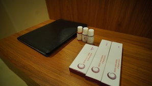 A wooden table with a black wallet, three small bottles, and three boxes labeled "HOTEL NEW GRAND." - Hotel New Grand (Deoghar)