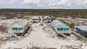 Une propriété située en bord de mer, comprenant plusieurs maisons de vacances reliées par une allée centrale.