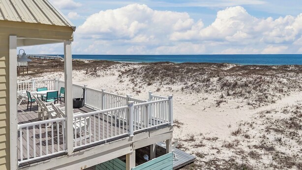 Une maison de plage avec un balcon donnant sur l’océan.