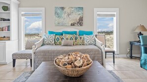 Une chambre à coucher avec un lit, une grande fenêtre, un tableau et un vase contenant des objets décoratifs.