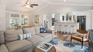 A modern living room with a sofa, a coffee table, and a ceiling fan. - 116 Sea Otter - Resort Access & Golf Cart! (Fripp Island)