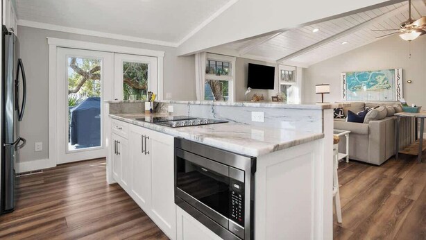 A modern kitchen with white cabinetry, a built-in oven, and a large island. - 116 Sea Otter - Resort Access & Golf Cart! (Fripp Island)