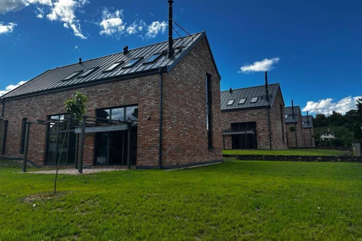 A modern brick building with a sloped roof and large windows.