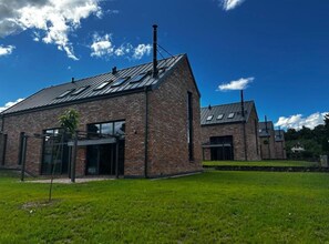 A modern brick building with a sloped roof and large windows. - Palace Inn (Jiloviste)