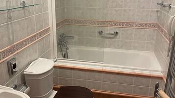 Une salle de bain comprenant des toilettes, un bidet, un lavabo et une baignoire.