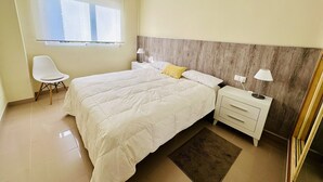 A bedroom with a bed, bedside tables, a chair, a window, and a nightstand. - T1029 - Comfort and Style in Cala de Villajoyosa (Villajoyosa)