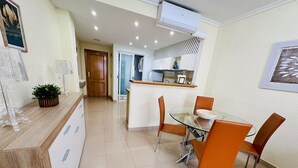 A modern kitchen with a glass dining table, orange chairs, and a white countertop. - T1029 - Comfort and Style in Cala de Villajoyosa (Villajoyosa)