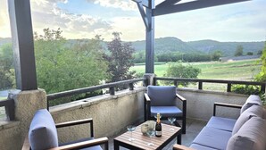 Ein überdachter Außenbereich mit Blick auf eine grüne Landschaft.
