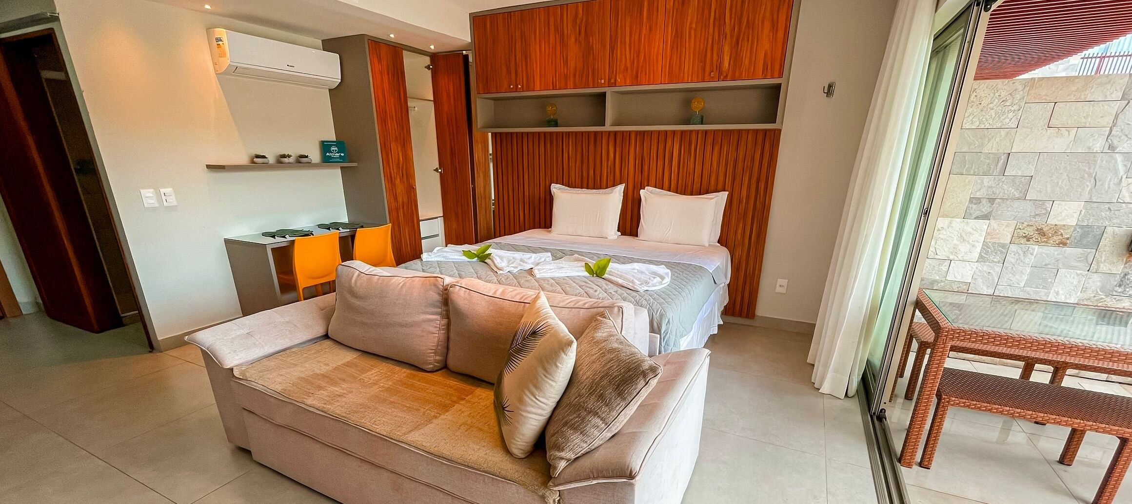 A modern bedroom with a bed, a sofa, and a dining area.