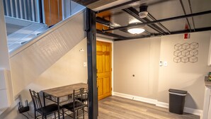 A modern interior with a staircase, a dining area, and a wooden door. - Lafayette Vibe Downtown District (Lafayette)