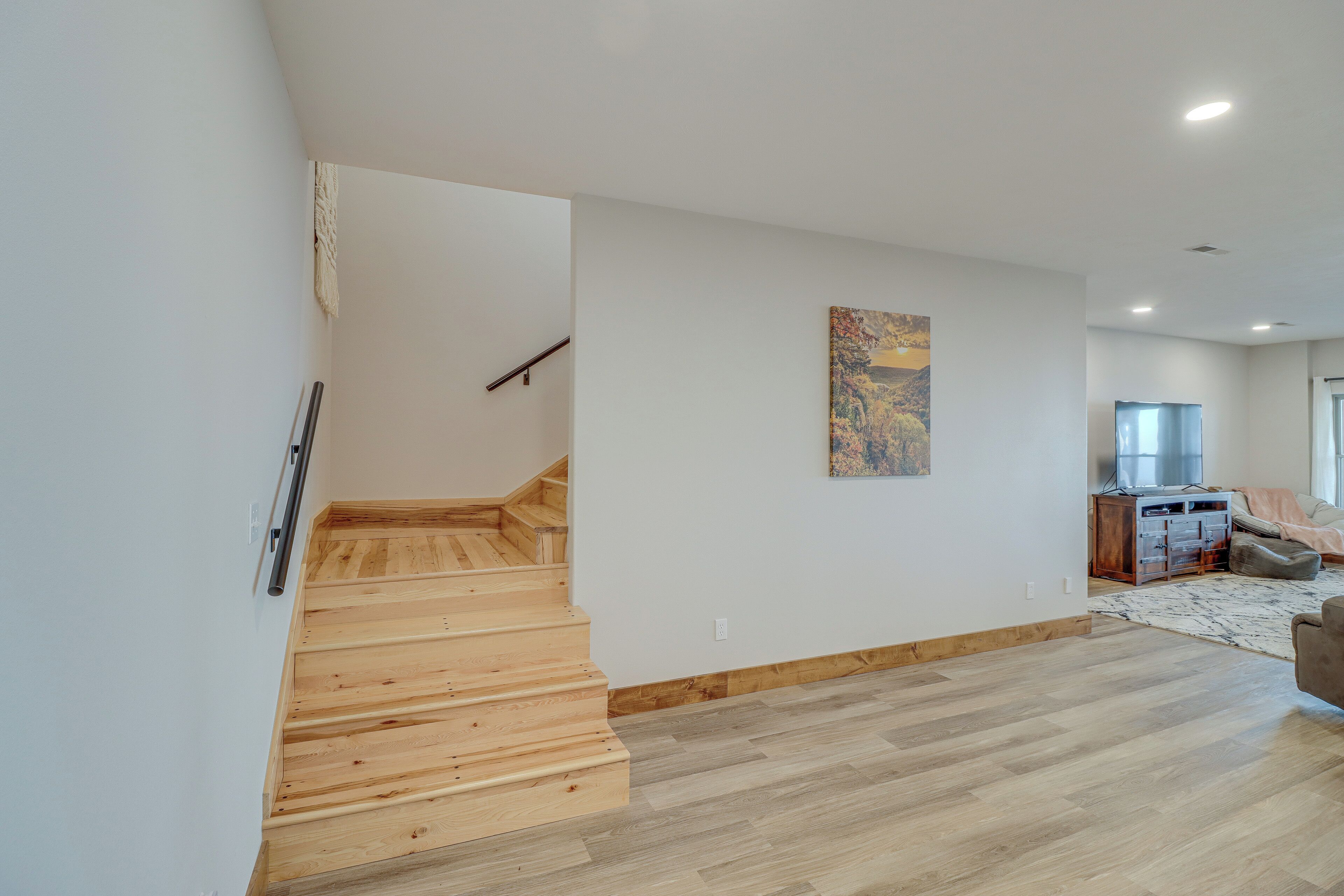 A modern interior with a wooden staircase, a dining area, and a kitchen.