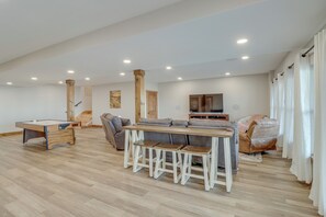 A spacious living area with a pool table, a sofa, and a TV. - Spacious Harrison Vacation Rental w/ Deck & Views! (Harrison)