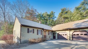A two-story house with a garage, a driveway, and a small front yard with shrubs. - Tranquil Ogunquit Condo: Walk to Beach & Marina! (Ogunquit)