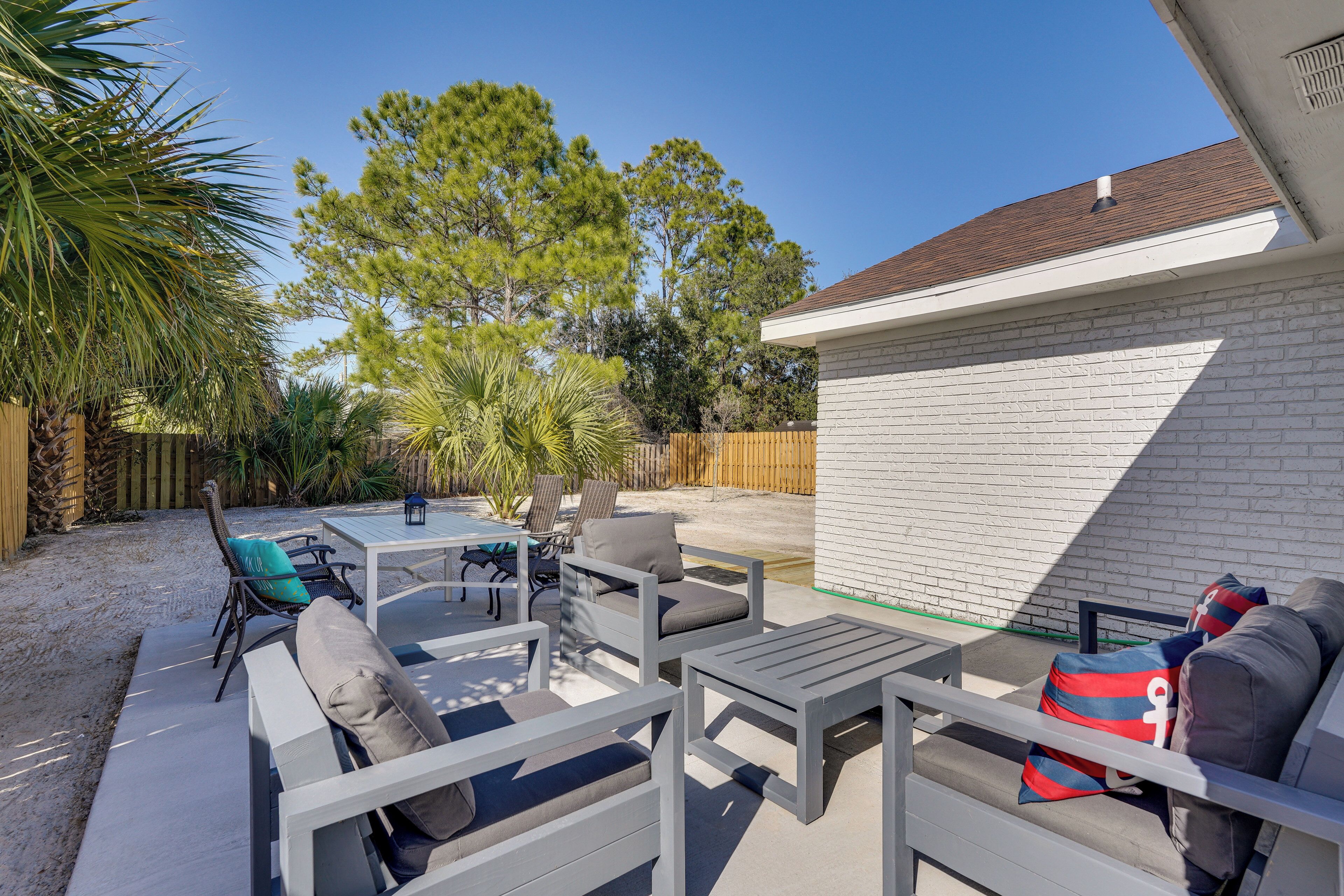 A patio area with outdoor furniture, a pool, and a white brick wall.