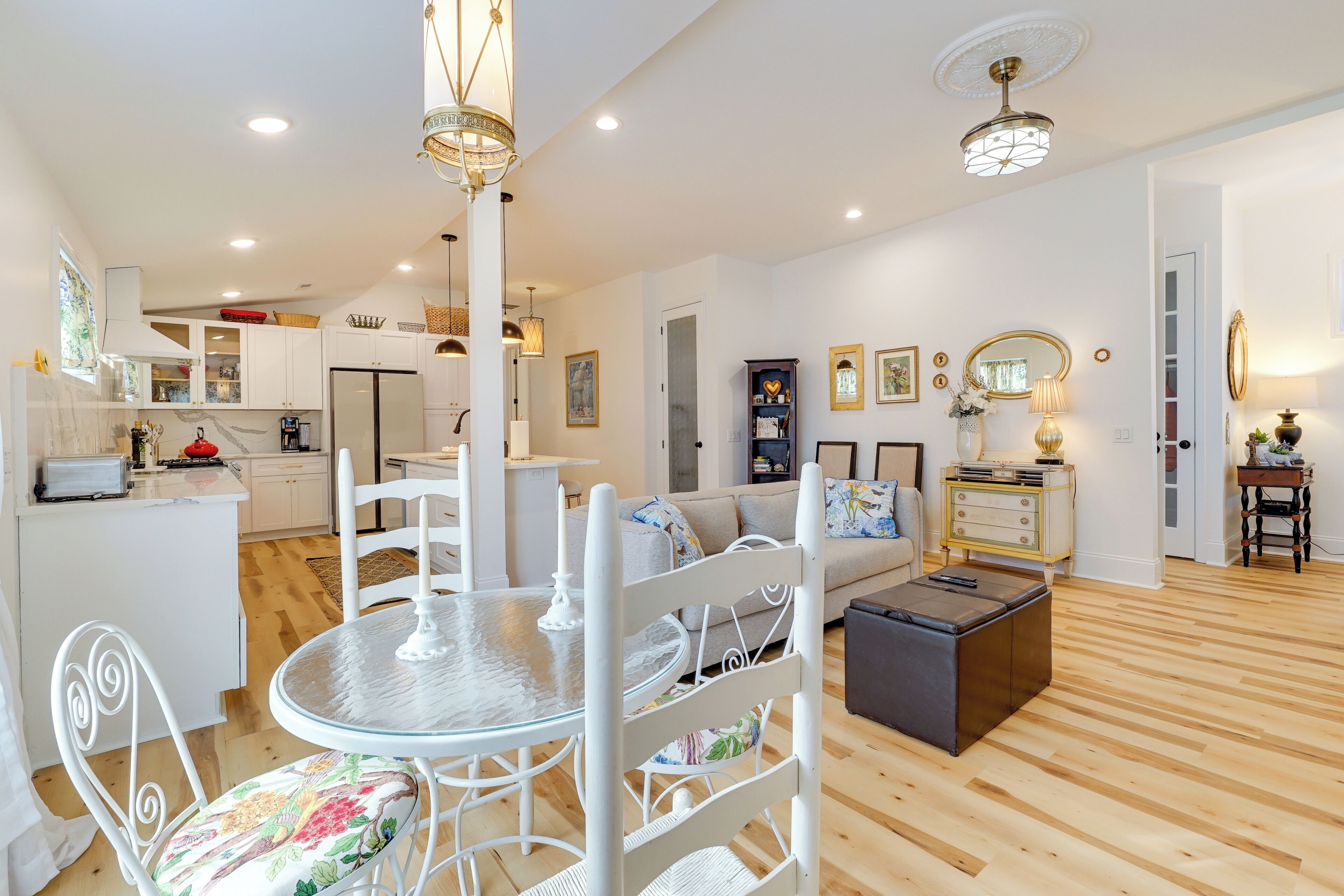 A modern living room with a dining area, kitchen, and a cozy seating area with a fireplace.