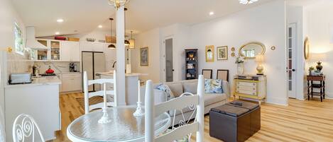 A modern living room with a dining area, kitchen, and a cozy seating area with a fireplace.