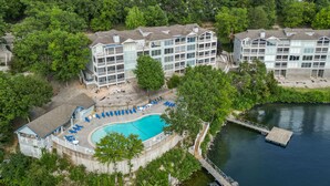 Ein Resort mit Schwimmbad, Liegestühlen, einer Anlegestelle und Blick auf einen See.