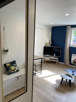 Una sala de estar moderna con televisor, una mesita y un banco.