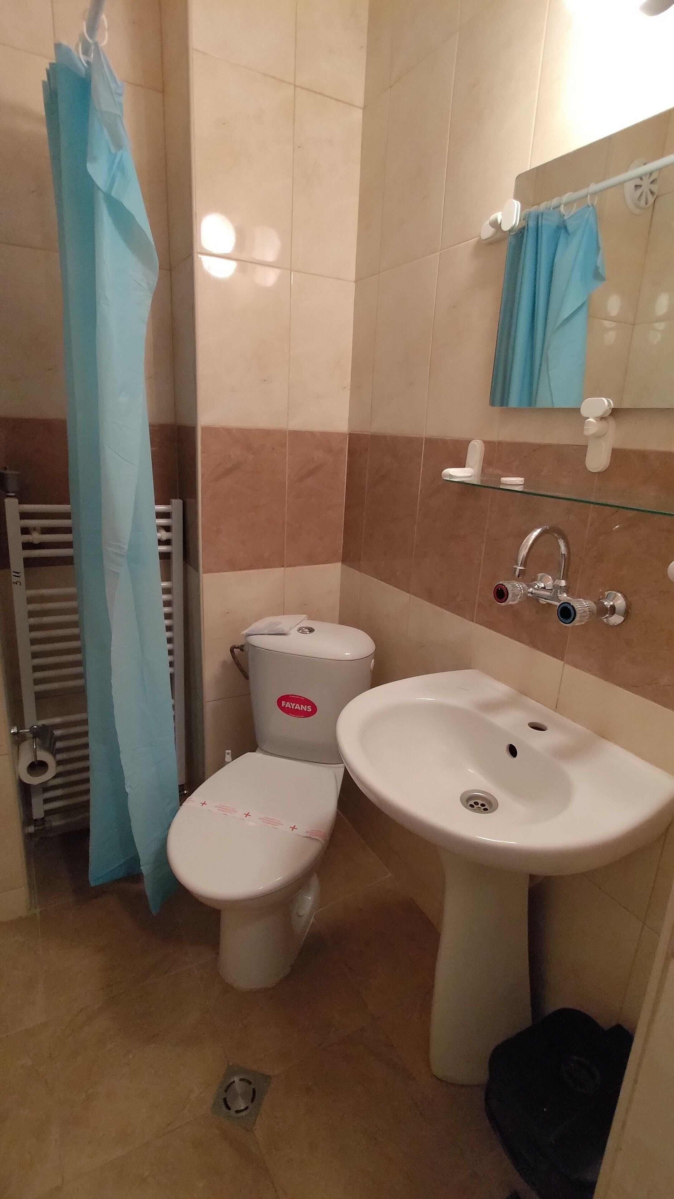Un baño con inodoro, bidé y lavamanos.