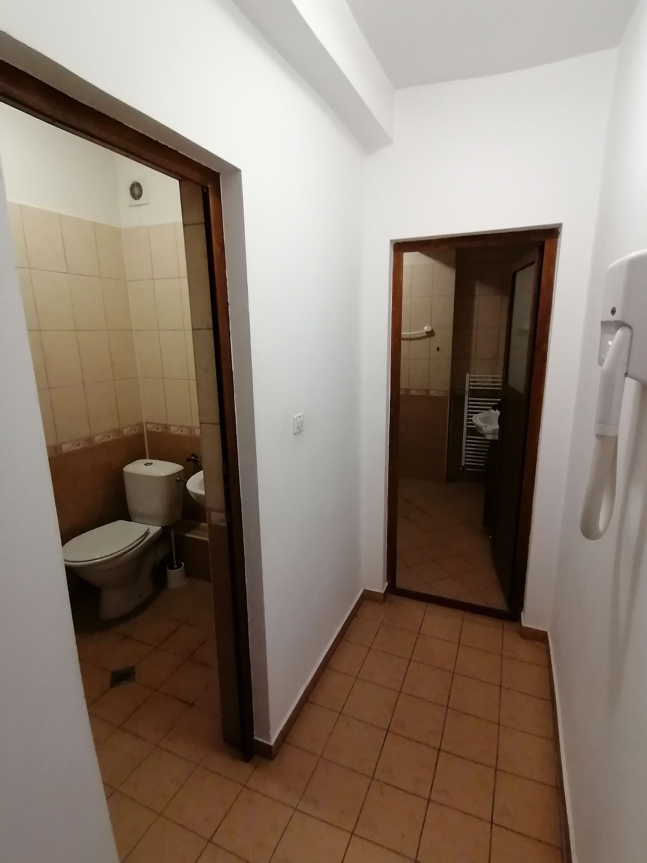 A compact bathroom with a toilet, sink, and shower area.
