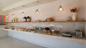 A kitchen with a marble countertop, hanging pendant lights, and various kitchen appliances and utensils. - Pousada Pazuu (Ubatuba)