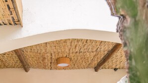 A room with a bed, a nightstand, and a hanging light fixture. - Pousada Pazuu (Ubatuba)