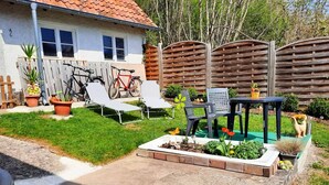 Patio trasero residencial con área de patio, bicicleta y mobiliario exterior.
