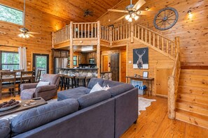 A cabin interior with a living room, kitchen, and a staircase. - Bison Point, Smoker Grill, Corn Hole, Fire Pit, Game Table, Ladder Ball (Broken Bow)