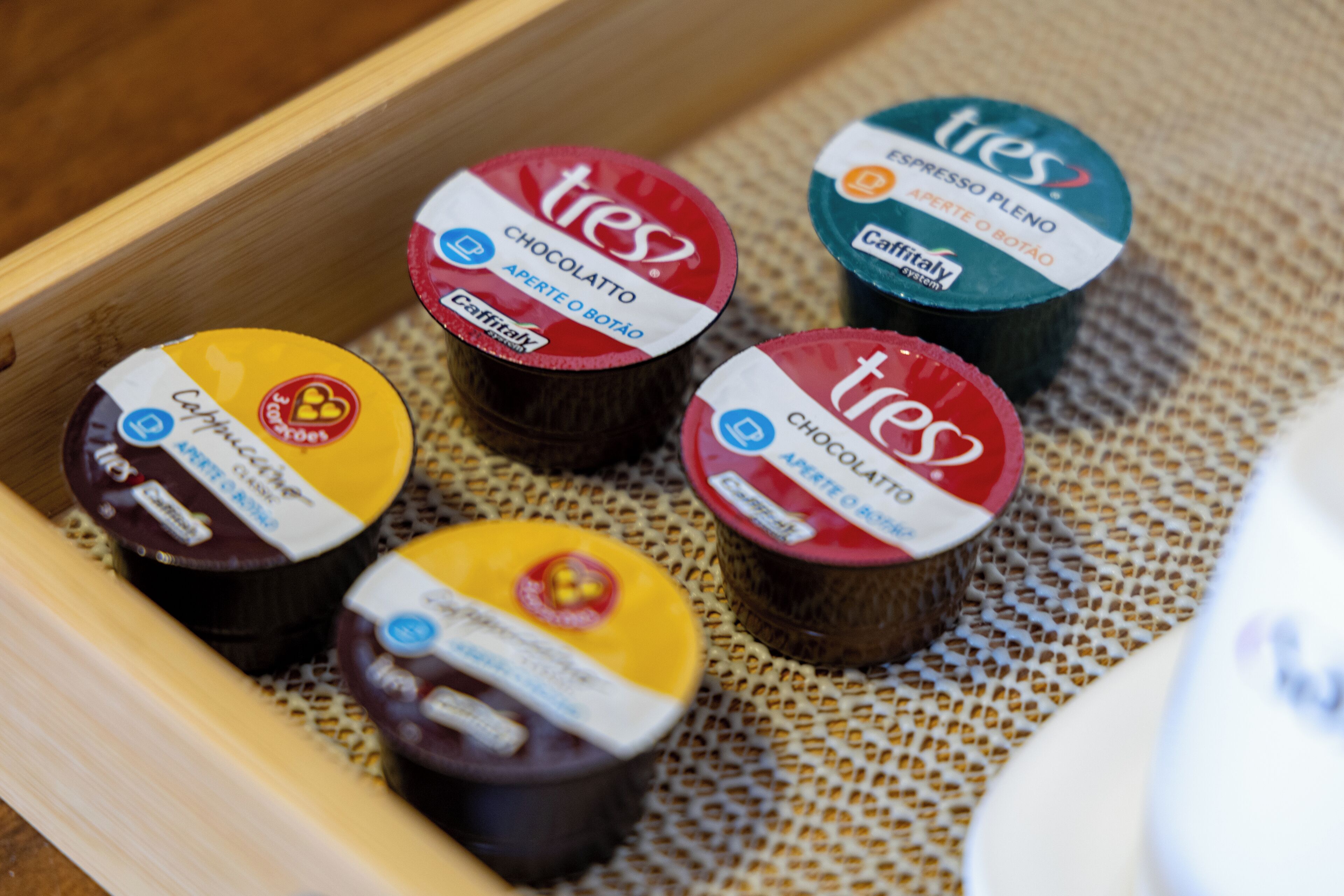 A tray with five containers of Tres coffee, each labeled with different flavors.