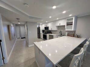 Kylskåp, kaffe- och tebryggare, grytor/köksredskap och matbord