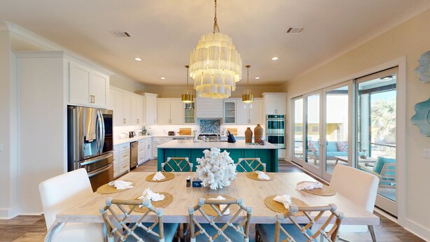 Una cocina moderna con armarios blancos, electrodomésticos de acero inoxidable y una isla grande con encimera azul turquesa.