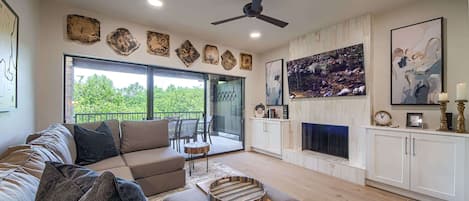 A living room with a sofa, a coffee table, a fireplace, and a television.