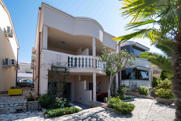 Guests can enjoy a balcony with a view of the courtyard, surrounded by lush plants and a palm tree.