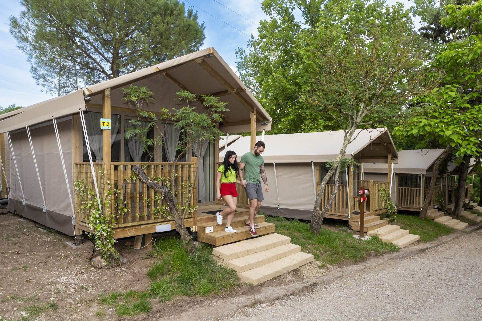 A small, single-story cabin with a wooden deck and a covered porch.
