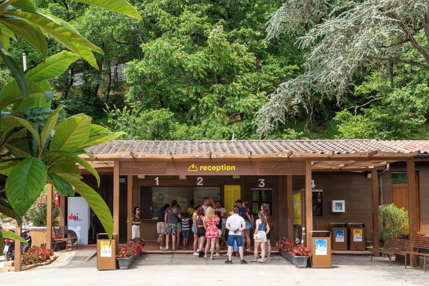 A reception area with numbered doors, a sign indicating reception, and people standing outside.