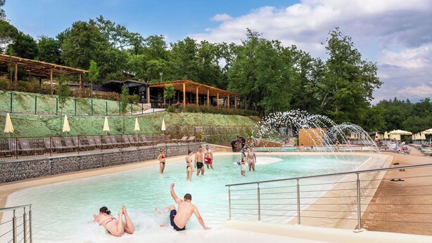 Un parc aquatique doté d’une piscine, de toboggans et d’une zone de détente en bois.