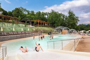 A water park with a pool, slides, and a wooden deck area. - hu Firenze Certosa camping in town (Impruneta)