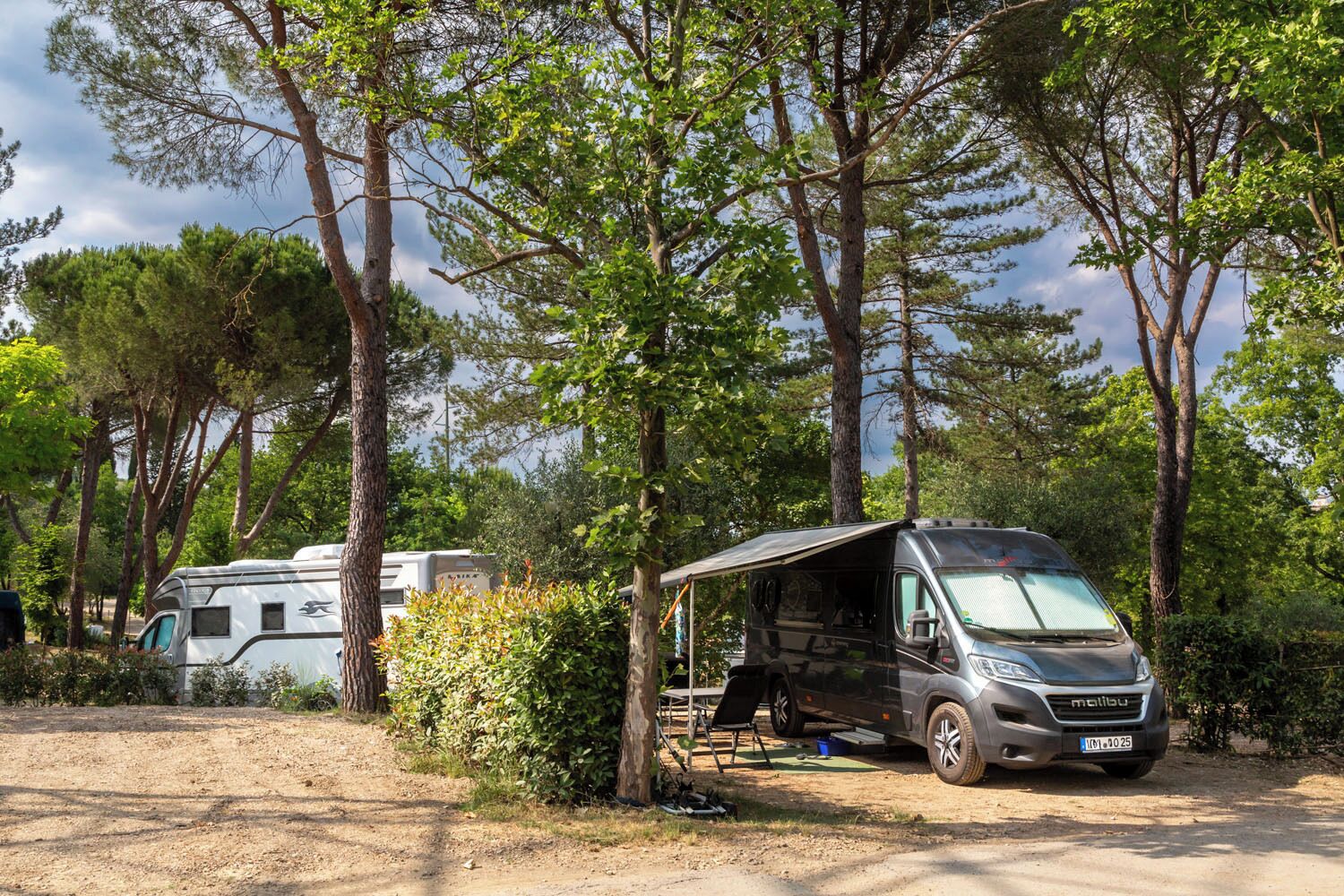 En campingplads med en autocamper og en campingvogn.