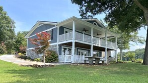 Une maison à deux étages, dotée d’un porche couvert et de fondations en pierre.