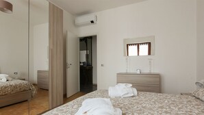 A hotel room with a bed, a bedside table, a mirror, and a wardrobe. - New Fashion District 3 BDRS (Milano)
