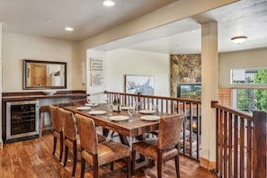 A dining area with a wooden table, leather chairs, and a view of the outdoors.