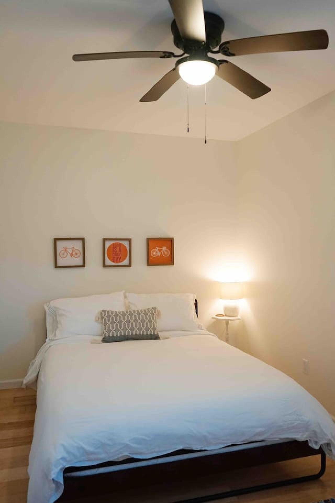 Ein Schlafzimmer mit einem Bett, einem Deckenventilator und Wandleuchten.