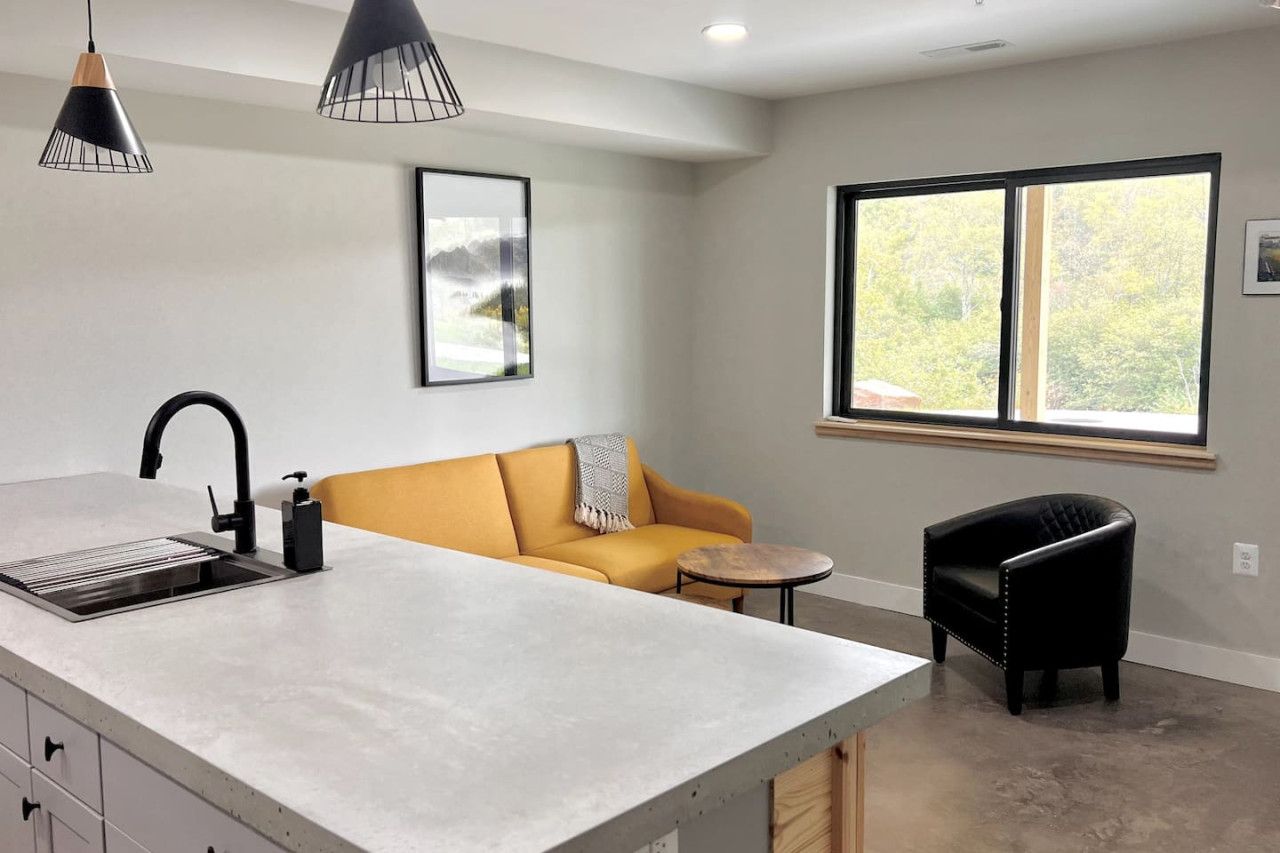 Una cocina moderna con una isla central, pileta integrada e iluminación colgante.