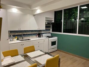 Enjoy meals in this kitchen with a view, featuring a stove, sink, and dining area.