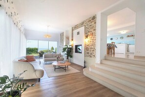 A modern living room with a sofa, coffee table, and a stone accent wall.