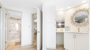 A modern kitchen with white cabinetry, a marble backsplash, and a decorative mirror. - Oceanfront , 3 Bedroom, 3 Bathroom with panoramic ocean views and pool access (Hilton Head Island)